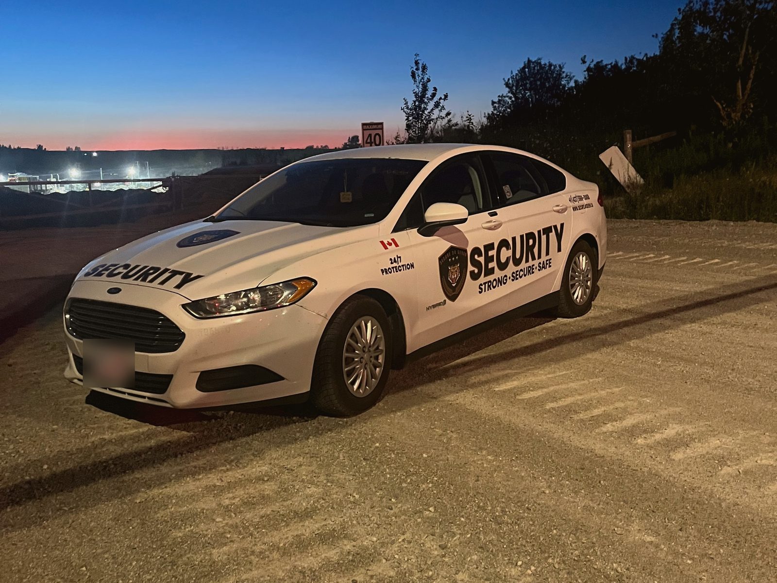 Secure 24 Seven patrol car at a construction site at dusk