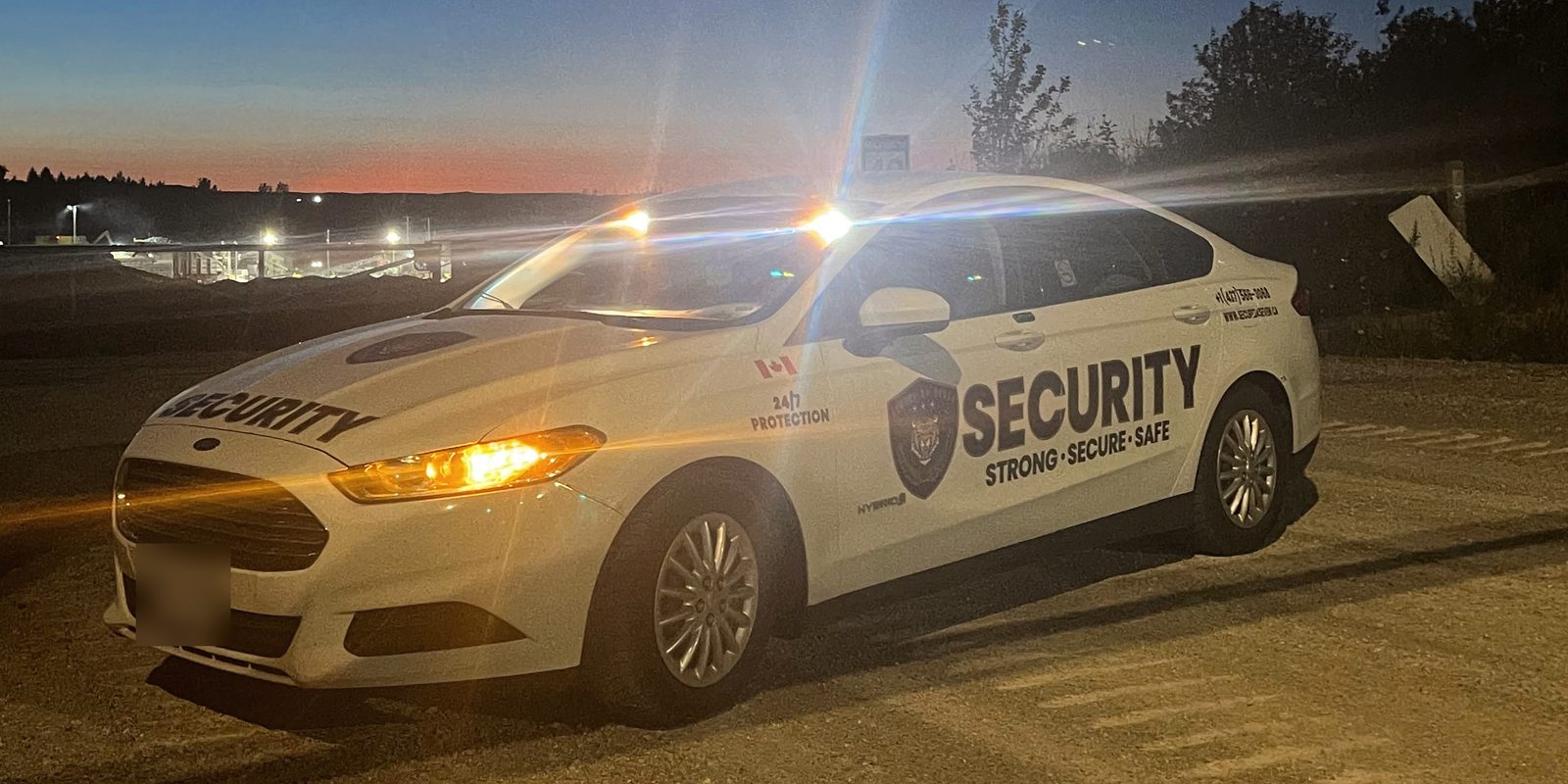 Secure 24 Seven patrol car at a construction site at dusk