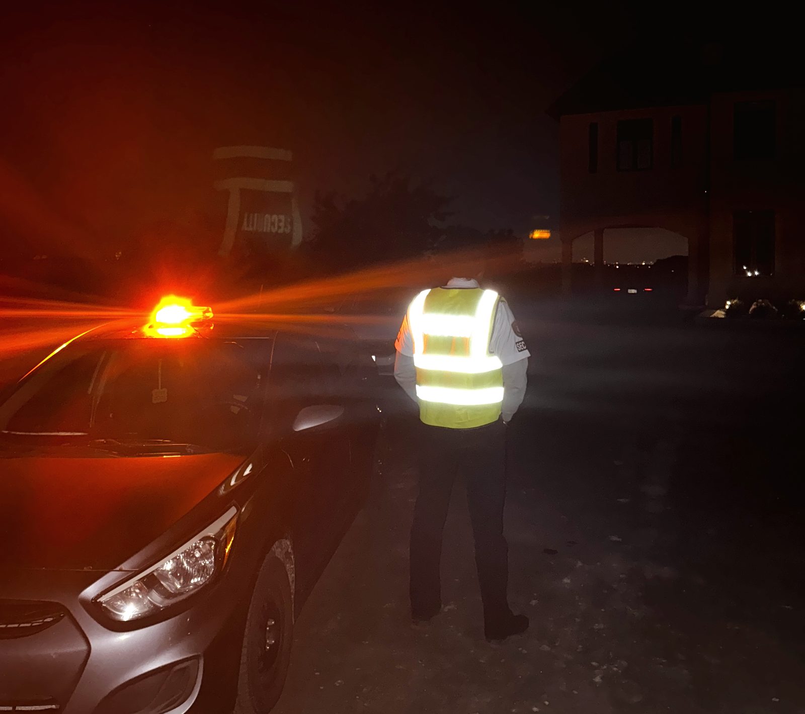 Secure 24 Seven guard checking a residential property at night