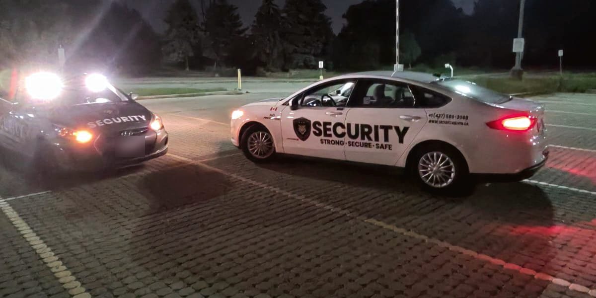 Secure 24 Seven patrol cars in a parking lot at night